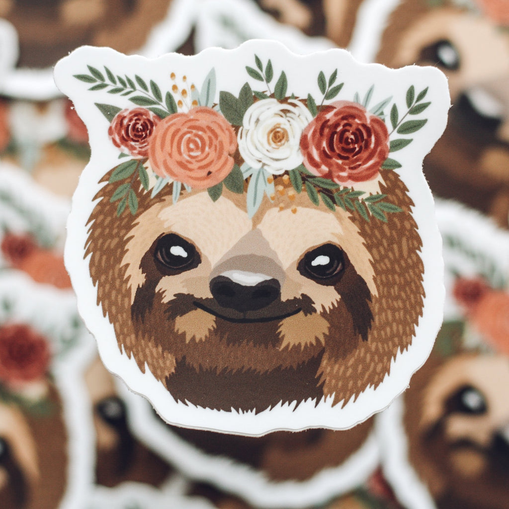 Sticker of brown smiling sloth wearing a floral crown